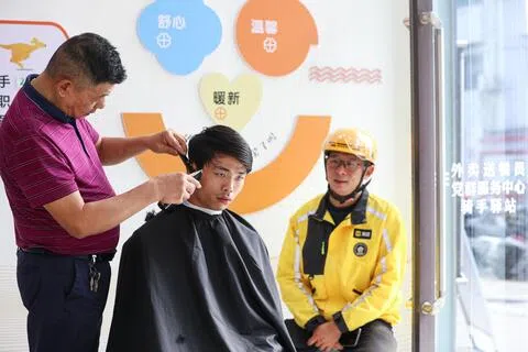 中国提出通过“数据找人”等多种措施动员参保，重点鼓励支持灵活就业人员等参加职工养老保险。图为江苏省海安市一名快递小哥在等待理发。（新华社）