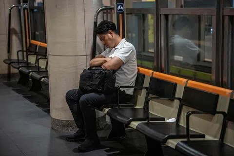 9月1日，一名男子在东京的地铁站内睡着。日本政府9月起取消此前将加班时间限制在“每月45小时以内”的行政指导，引发社会担忧日本职场将倒退回过去的“工作狂”模式。（法新社）