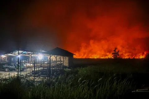 印尼中加里曼丹省首府帕朗卡拉亚（Palangkaraya）地区的林火蔓延，已逼近居民区。10月8日夜间，当地烈焰冲天、浓烟密布。（法新社）