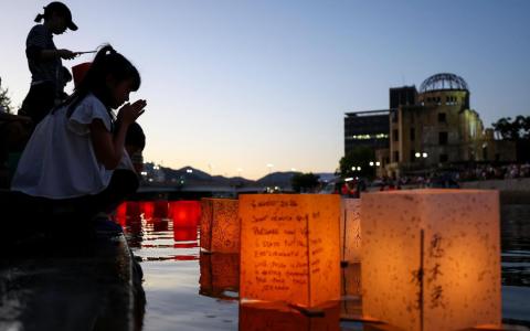 8月6日是广岛原子弹爆炸81周年，一些民众当天在原子弹爆炸圆顶屋前的元安川上放置纸灯笼，悼念核爆遇难者。（路透社）